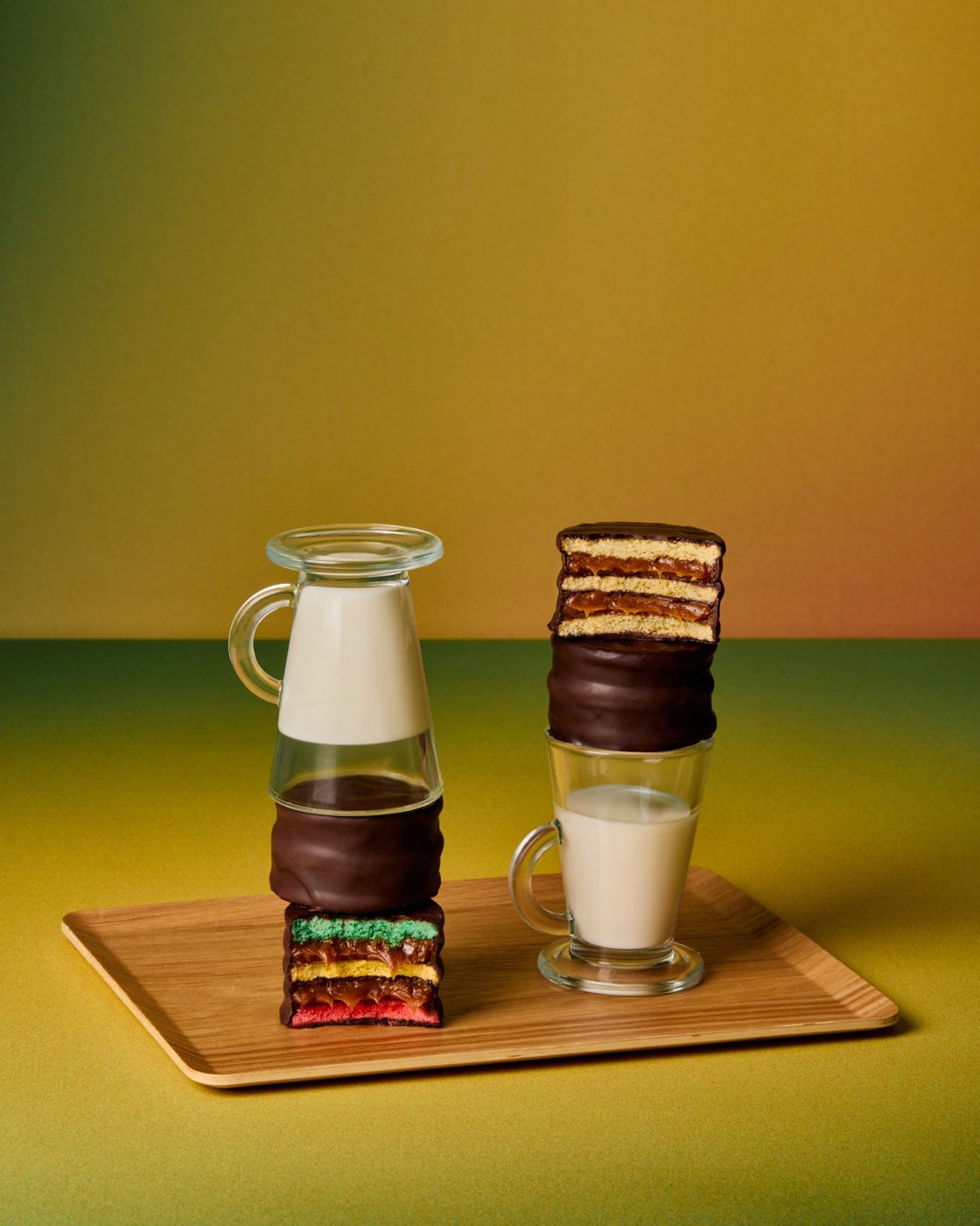 Trico y Trico Maicena cortados, apilados con vasos de leche sobre una bandeja